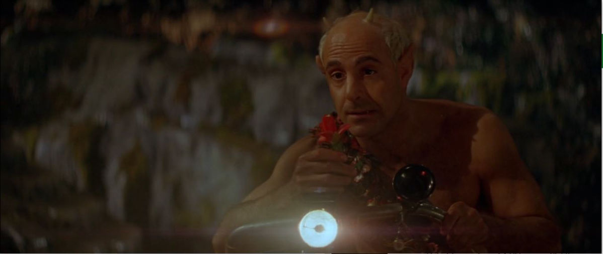 Stanley Tucci as Puck on a bicycle